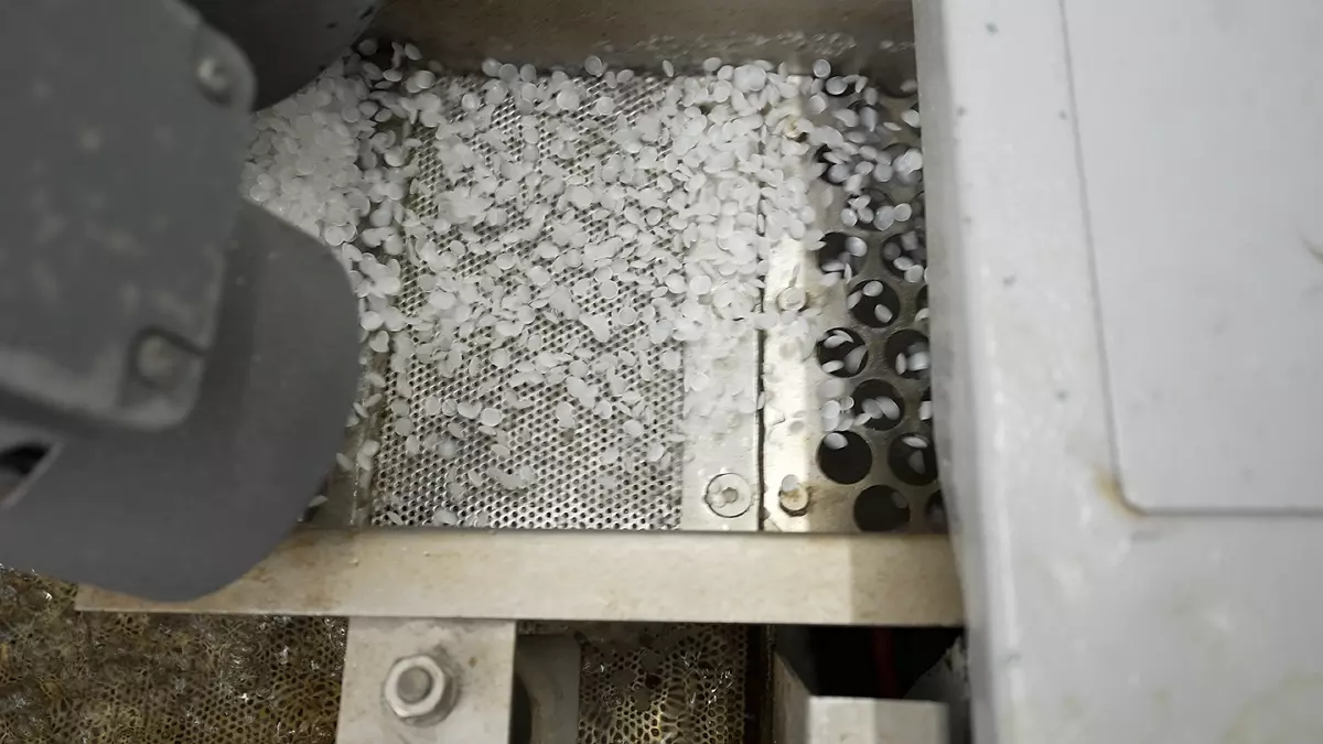 Circular resins being sifted through a machine