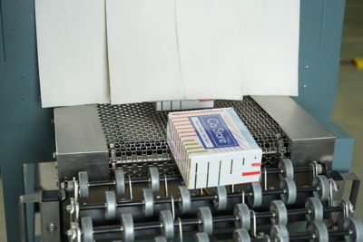 Boxed product moving through a conveyor sealing machine