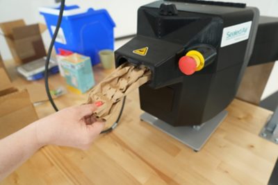 ProPad Mini dispensing crumpled paper cushioning at a packing station
